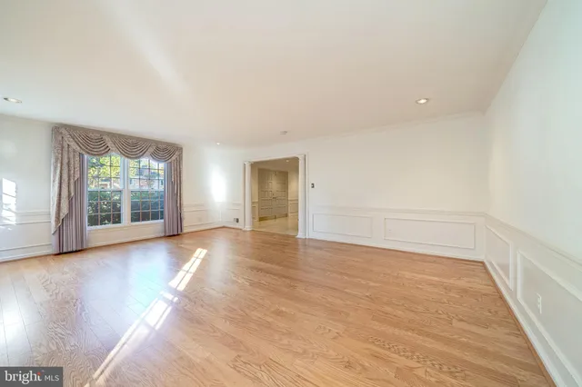 a view of empty room with wooden floor and fireplace