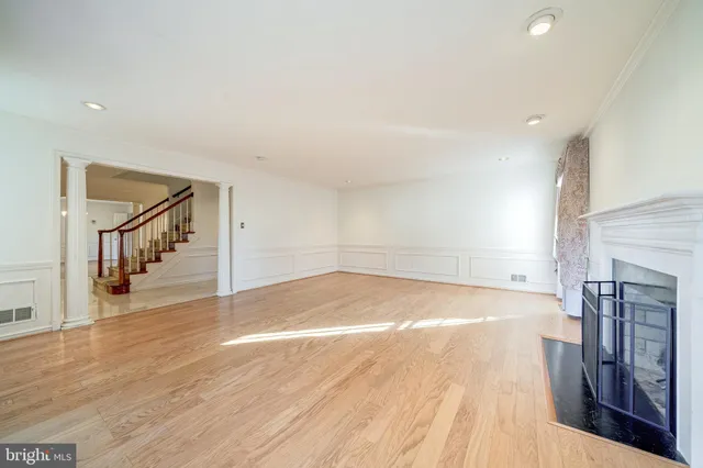 an empty room with wooden floor and window