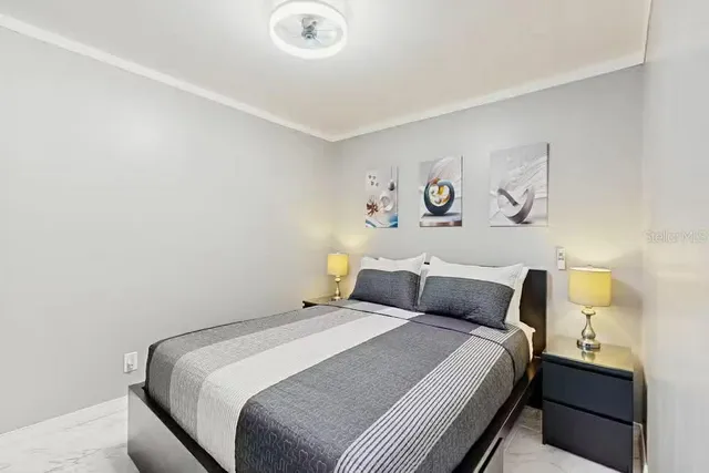 a bedroom with a bed and painting on the wall