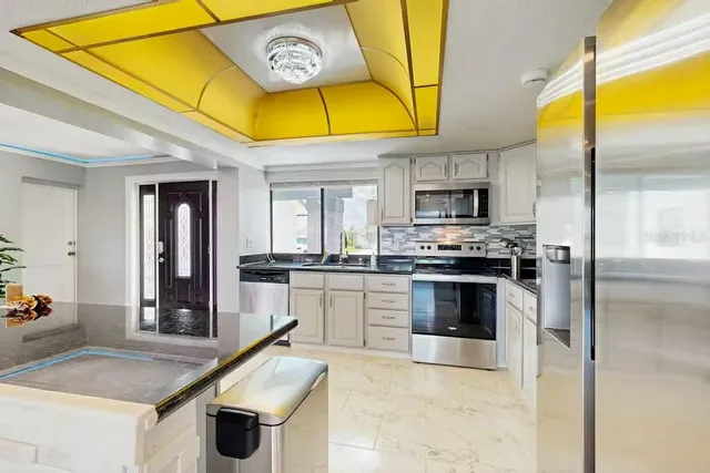 a kitchen with stainless steel appliances granite countertop a stove and a sink
