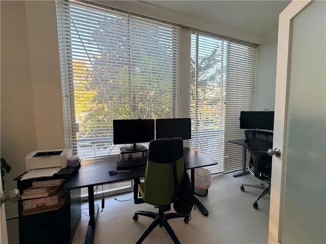a view of a workspace with furniture and a window