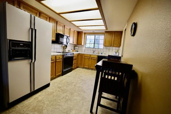 a kitchen with granite countertop a refrigerator stove and sink
