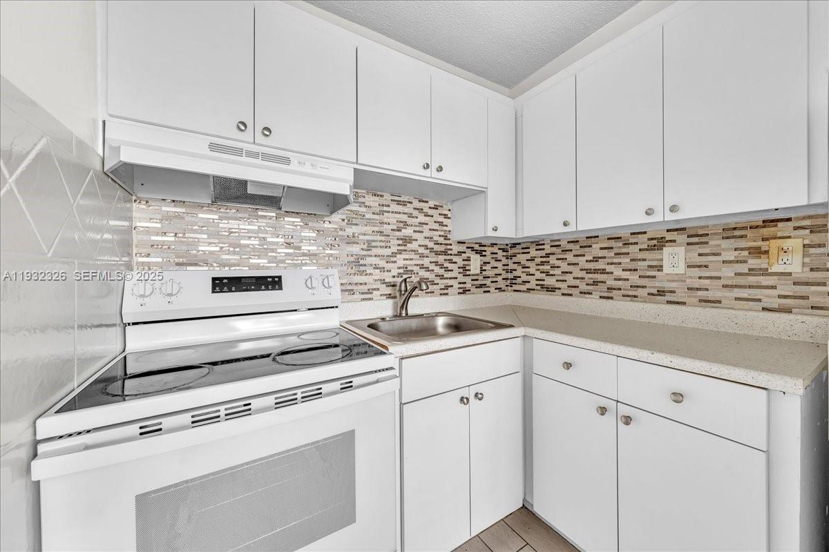 2025 Miami Road, Unit 19 Fort Lauderdale, FL 33316 - Photo 15 of 30 a kitchen with white cabinets and white appliances