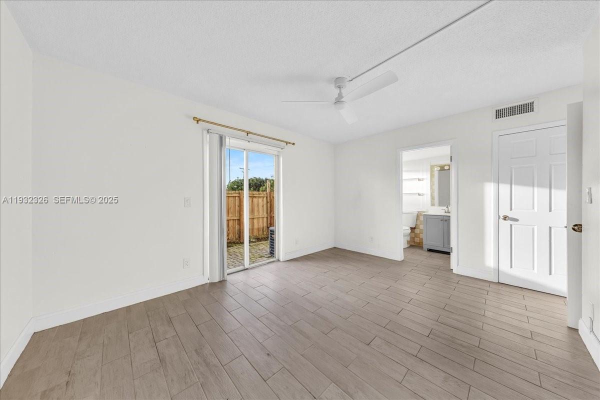 2025 Miami Road, Unit 19 Fort Lauderdale, FL 33316 - Photo 19 of 30 an empty room with wooden floor and windows