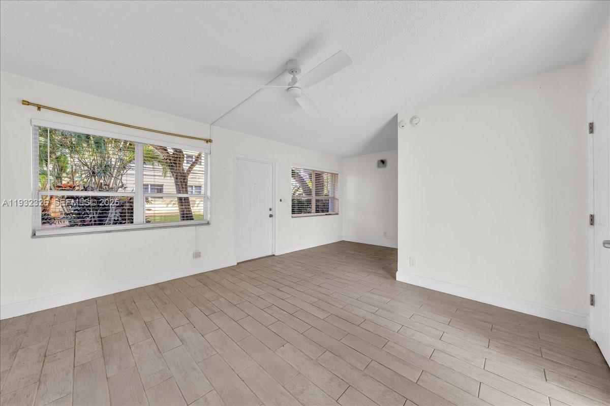 2025 Miami Road, Unit 19 Fort Lauderdale, FL 33316 - Photo 7 of 30 a view of an empty room with a window and wooden floor