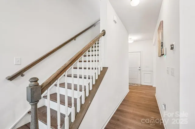 a view of a hallway with wooden floor and staircase