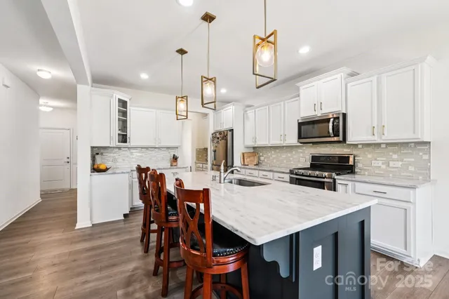 a kitchen with a dining table chairs refrigerator and microwave