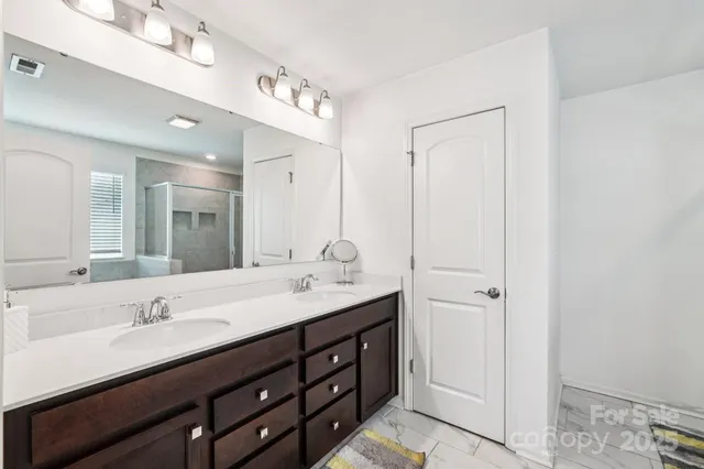 a bathroom with a double vanity sink and mirror