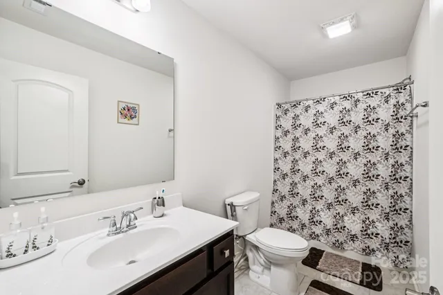 a bathroom with a sink toilet and a mirror