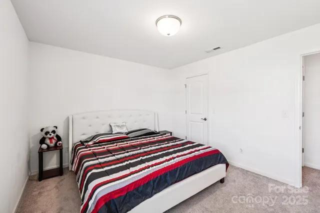 a bedroom with a bed and a potted plant on a dresser