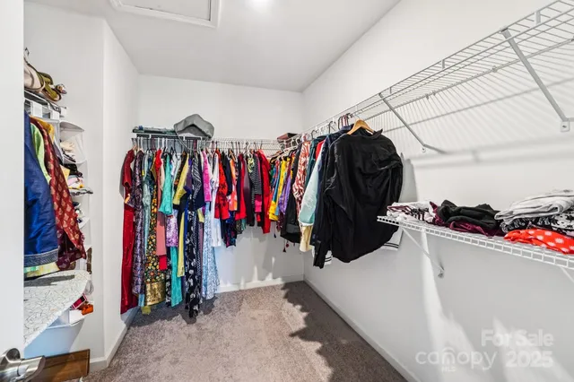 a view of walk in closet with clothes
