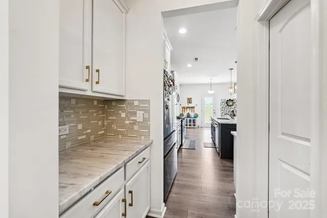 a view of a kitchen with refrigerator and wooden floor
