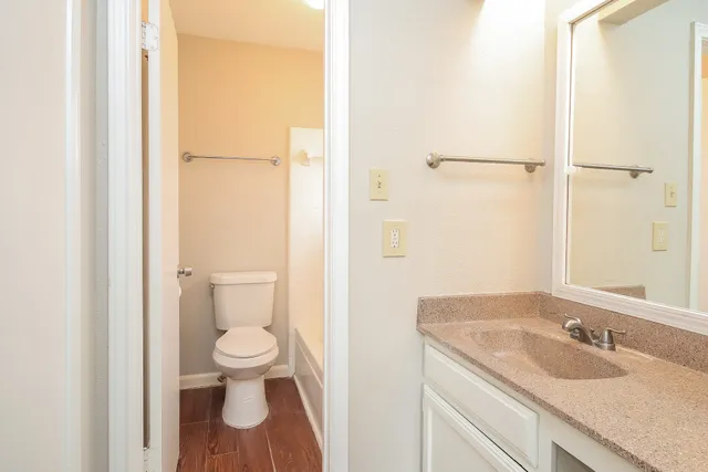a bathroom with a granite countertop sink toilet and shower