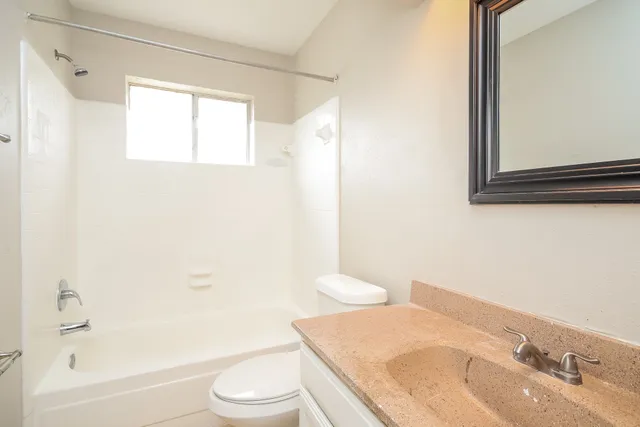 a bathroom with a granite countertop sink toilet and shower