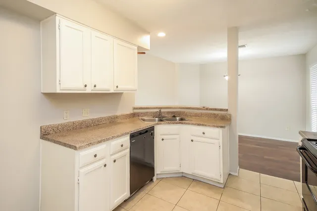 a kitchen with granite countertop white cabinets and a sink