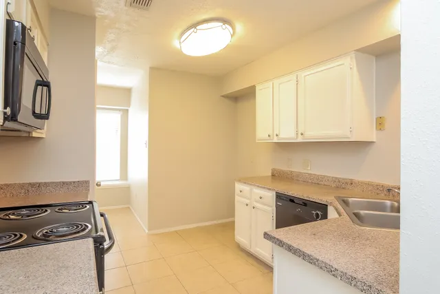 a kitchen with granite countertop a stove and a sink
