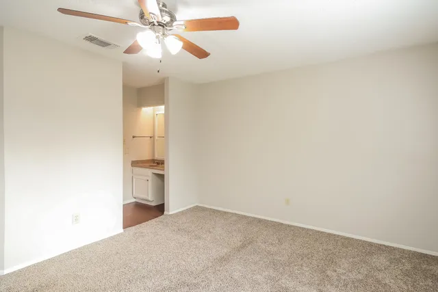 a view of empty room with window and ceiling fan