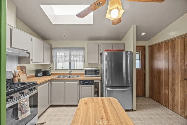 a kitchen with granite countertop stainless steel appliances a sink cabinets and a counter top space