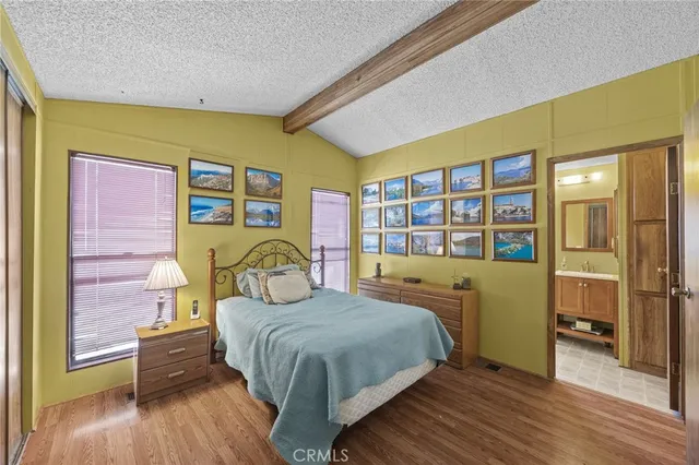 a bedroom with a bed and a dresser next to a window