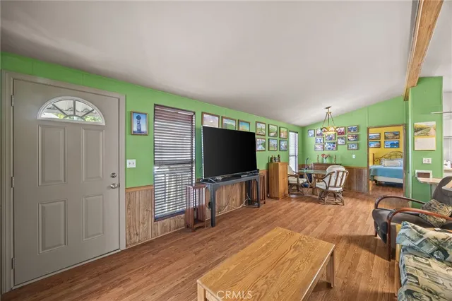 a living room with furniture a flat screen tv and a large window