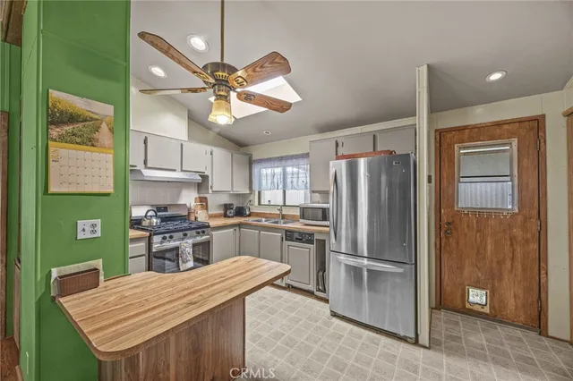 a kitchen with stainless steel appliances kitchen island a refrigerator and a stove top oven