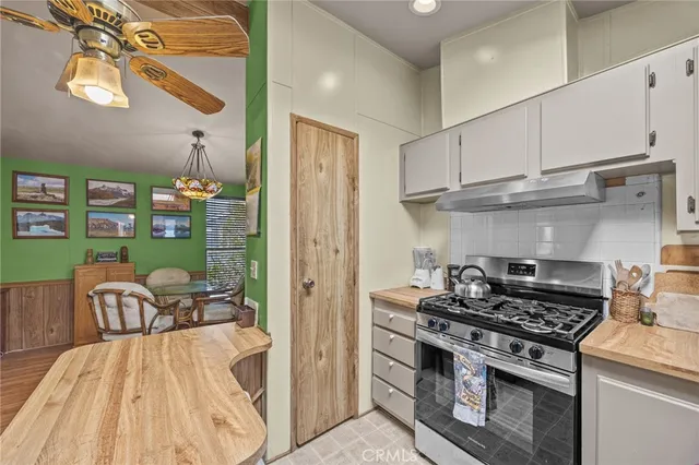 a kitchen with stainless steel appliances granite countertop a stove a refrigerator and a view of living room