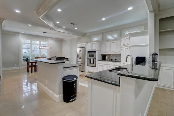 a kitchen with stainless steel appliances granite countertop a sink refrigerator and cabinets