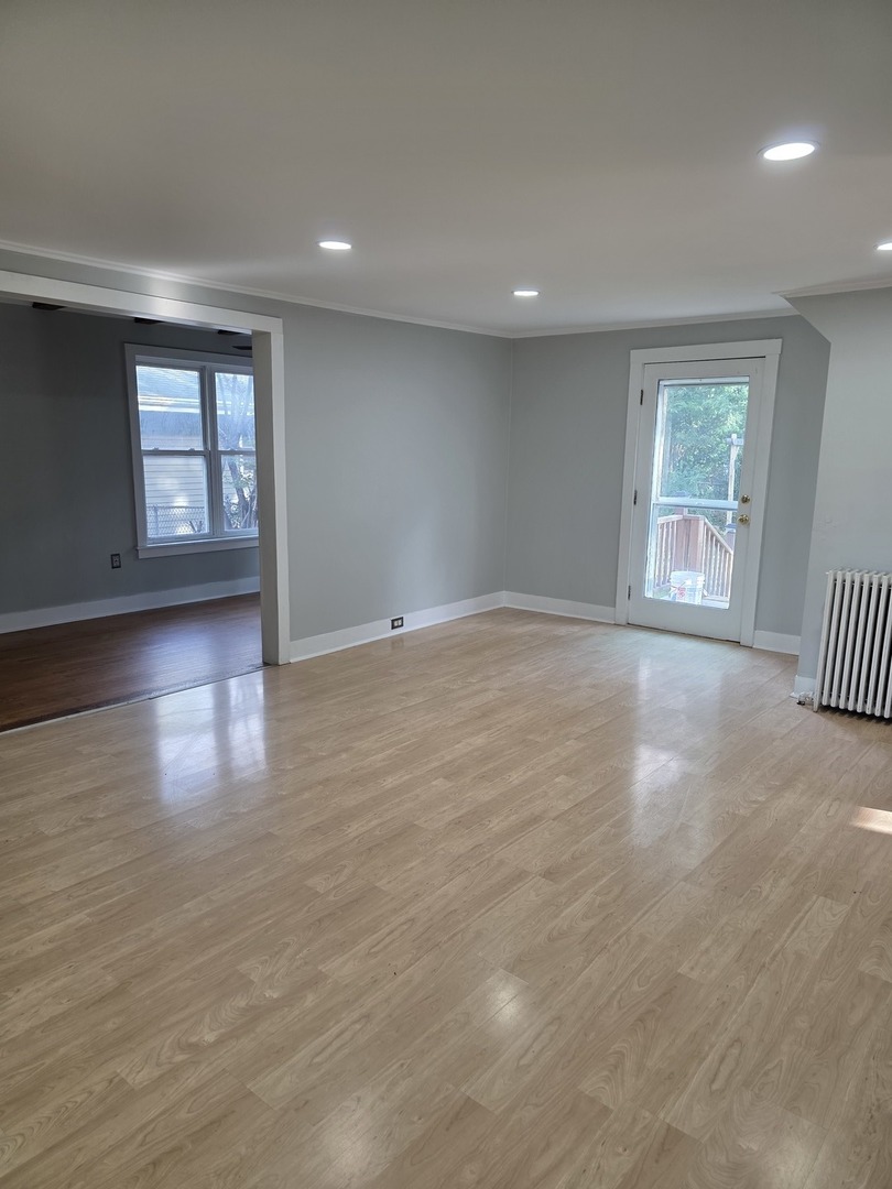 302 Dee Road North Aurora, IL 60542 - Photo 12 of 13 a view of an empty room with wooden floor and a window