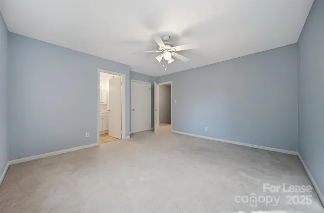 an empty room with a ceiling fan and a window