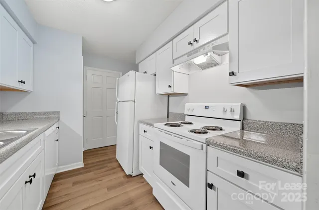 a kitchen with a stove cabinets and wooden floor