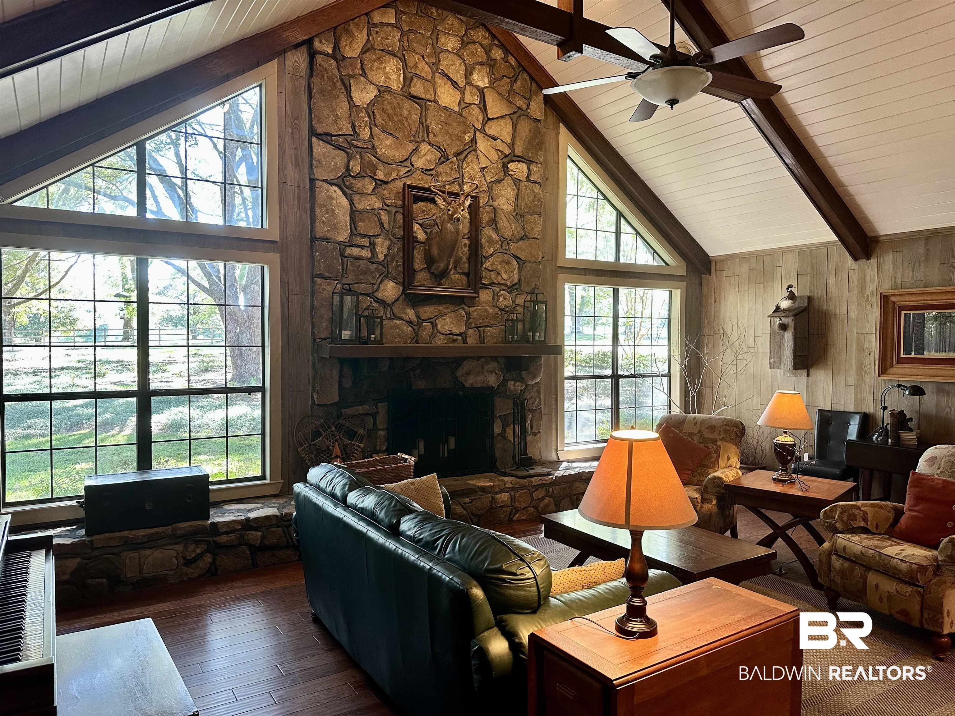 117 Belle Meade Brewton, AL 36426 - Photo 3 of 62 Living room featuring plenty of natural light, dark hardwood / wood-style floors, wooden walls, and a stone fireplace
