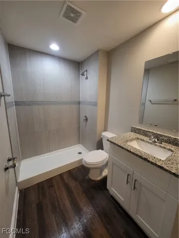 a bathroom with a granite countertop sink toilet and shower