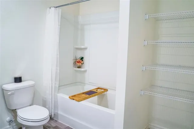 a bathroom with a toilet and a shower