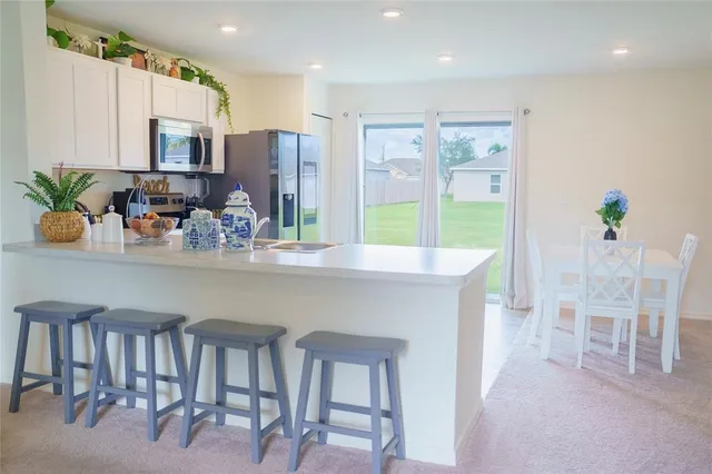 a kitchen with a table chairs refrigerator and microwave