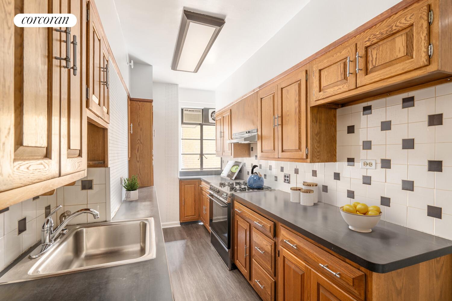 5 Riverside Drive, Unit 5A Manhattan, NY 10023 - Photo 4 of 13 a kitchen with stainless steel appliances a sink and a window
