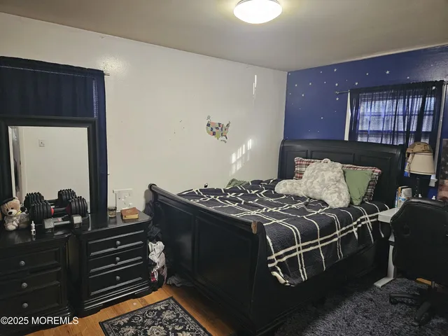 a bed sitting in a bedroom next to a window with dresser