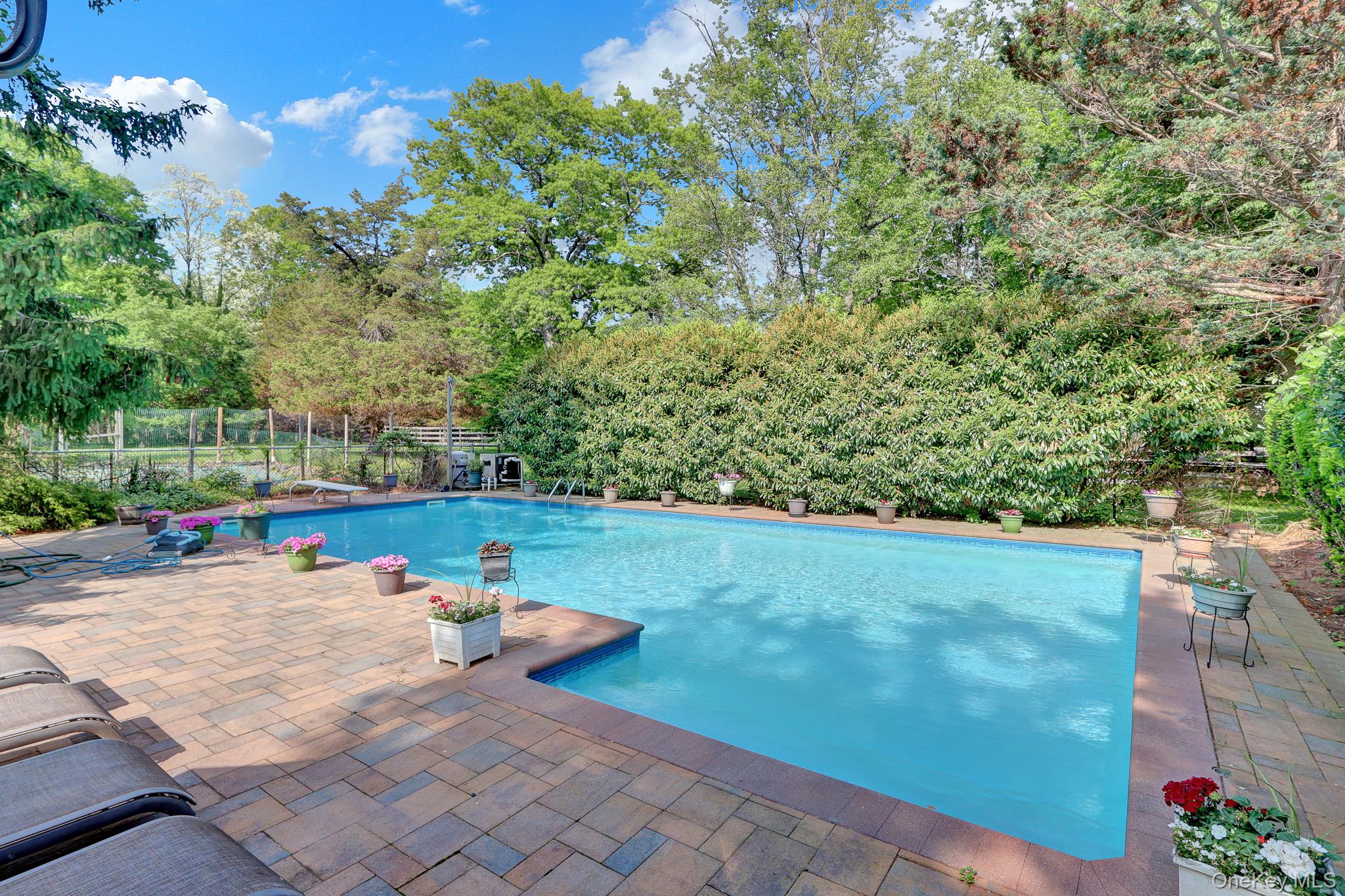 15 Stillwater Road Nissequogue, NY 11780 - Photo 30 of 43 In-ground swimming pool featuring a paver patio surround and mature perimeter landscaping