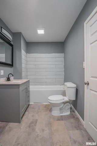 a bathroom with a toilet a sink a mirror and a bathtub