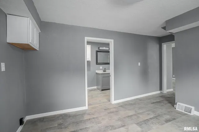 a view of an empty room with closet and a window