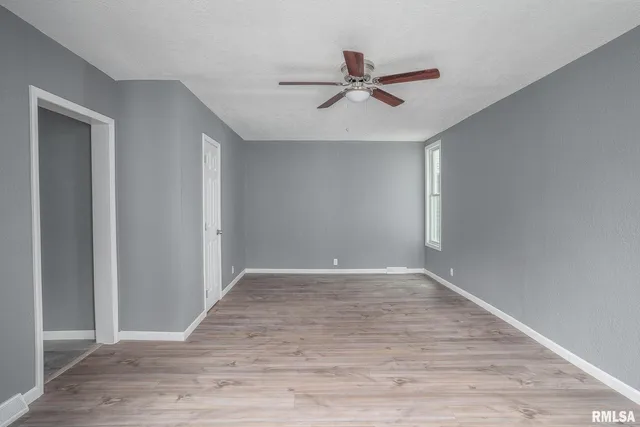 a view of a room with wooden floor and fan