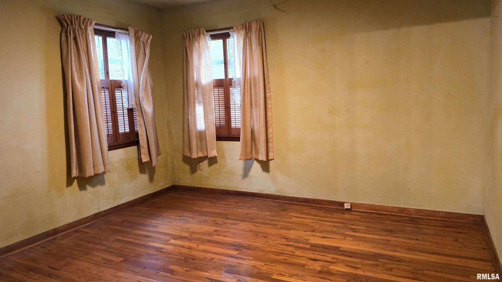 1028 Coyne Center Road Milan, IL 61264 - Photo 13 of 21 an empty room with wooden floor and a window