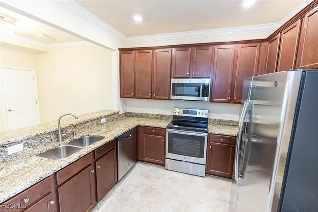 a kitchen with stainless steel appliances granite countertop a sink stove and refrigerator