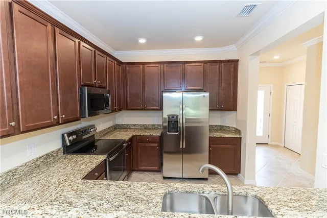 a kitchen with stainless steel appliances granite countertop a refrigerator a stove and a sink with granite countertops