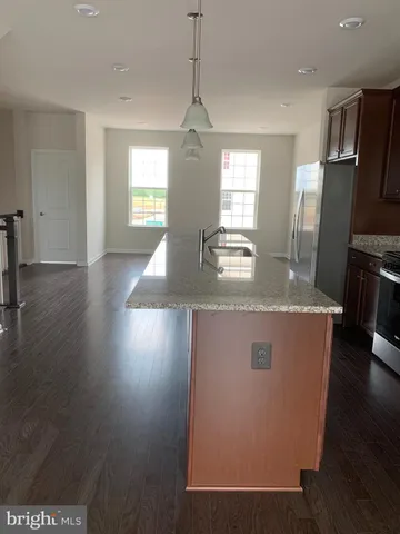 a view of kitchen with sink refrigerator and window