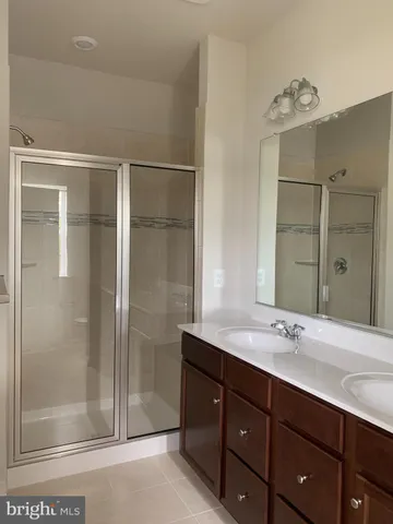 a bathroom with a double vanity sink mirror and shower