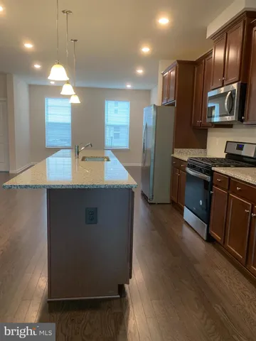 a kitchen with kitchen island granite countertop wooden cabinets and stainless steel appliances