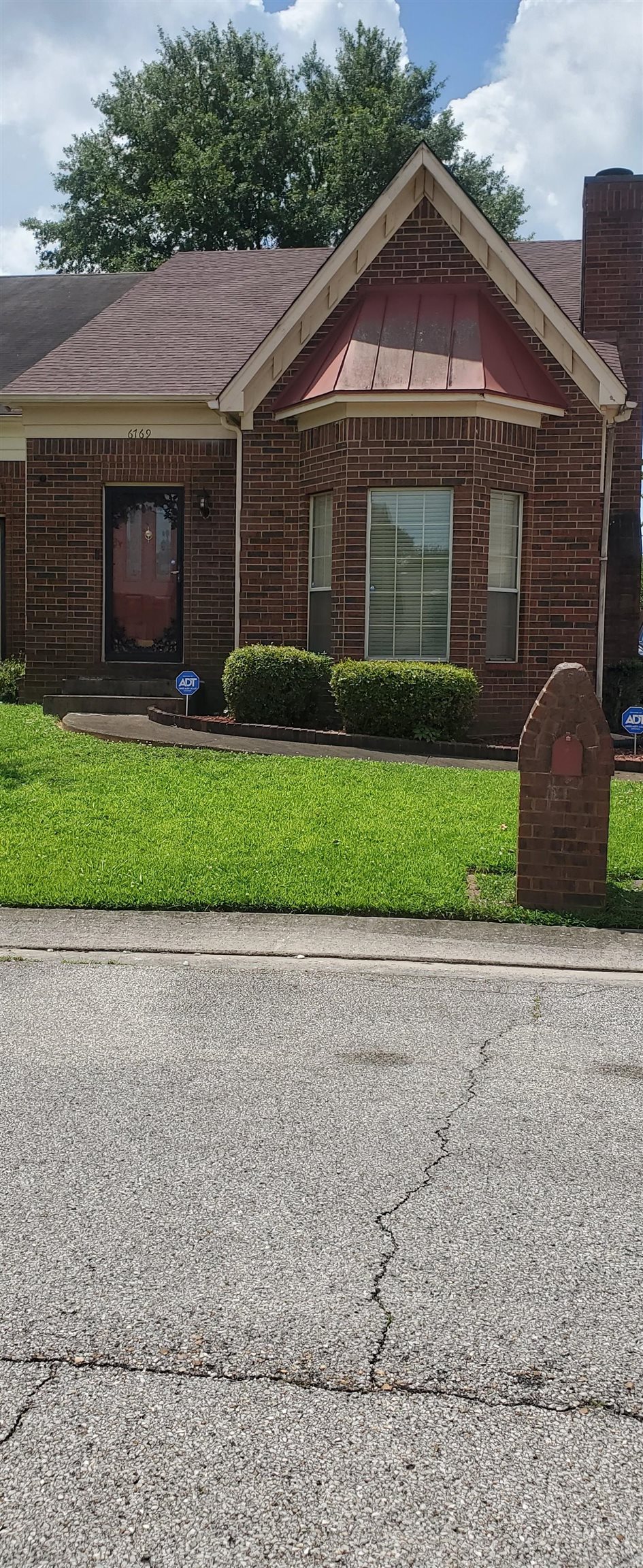 6769 Ross Ridge Drive Memphis, TN 38141 - Photo 1 of 25 a front view of a house with a garden and plants