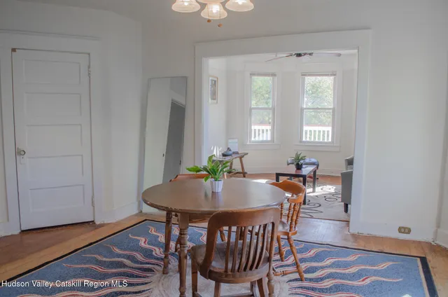 a view of a a dining room with furniture window and wooden floor