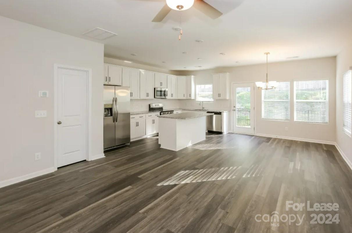 2002 Commerce Drive Monroe, NC 28110 - Photo 4 of 7 a kitchen with a wooden floor and white appliances