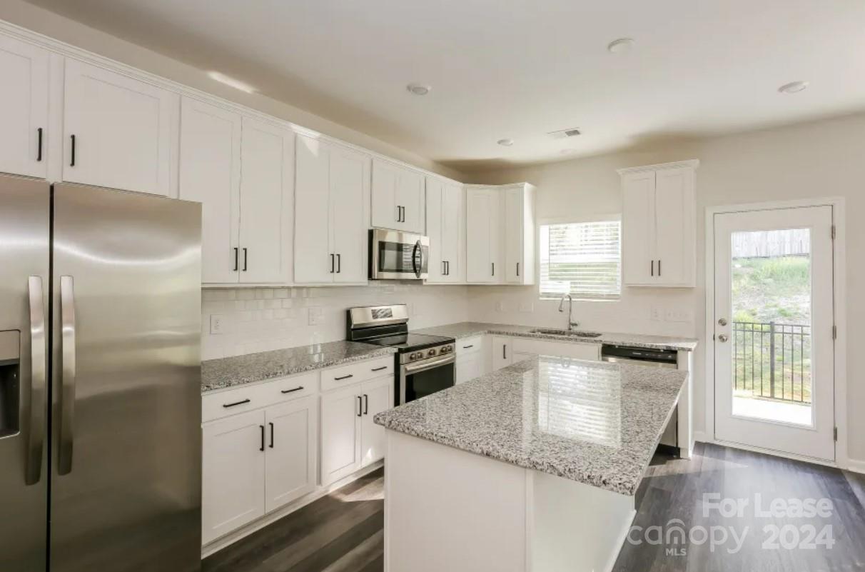 2002 Commerce Drive Monroe, NC 28110 - Photo 6 of 7 a kitchen with granite countertop white cabinets and white appliances